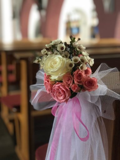 Dekorative Blumensträußchen mit langer Tüllschleppe für Kirchenbänke zur Hochzeit.