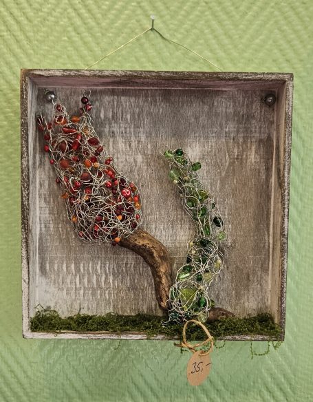 Ein Wandbild. Ein Tablett mit Treibholz vom Rheinufer und einem aus Draht und Perlen geformten Bäumen.