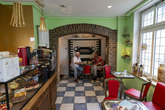 Gäste im Kunst-Café in Marienbaum trinken Kaffee und unterhalten sich in entspannter Atmosphäre.